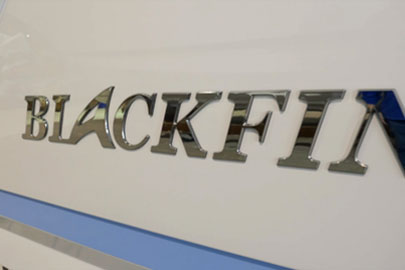 Close-up of the Blackfin boat logo badge on a white hull.